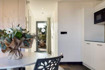 Entrée d’un appart-hôtel avec coin repas, décoration florale et accès au séjour près de Colmar, en Alsace