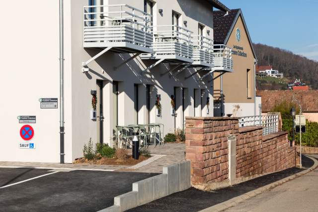 Fassade eines Aparthotels mit Balkonen, Außentreppen und Zugang zu den Wohnungen der Appartements Husseren Collections in der Nähe von Colmar im Elsass
