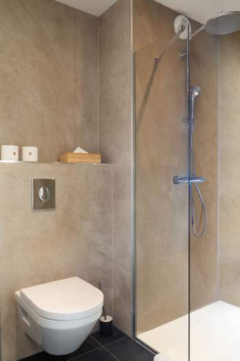 Salle de bain d’un appart-hôtel avec douche à l’italienne, paroi vitrée et robinetterie moderne près de Colmar, en Alsace