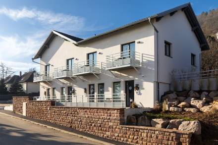 Serviced apartment façade with balconies and exterior access at Husseren Collections Apartments, near Colmar, Alsace