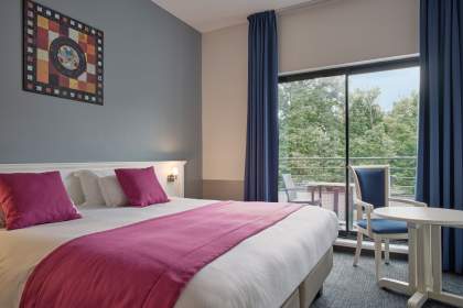 Zimmer im 3-Sterne-Hotel Marso mit zwei Einzelbetten, roten Sesseln, Sitzecke und moderner Einrichtung im Elsass