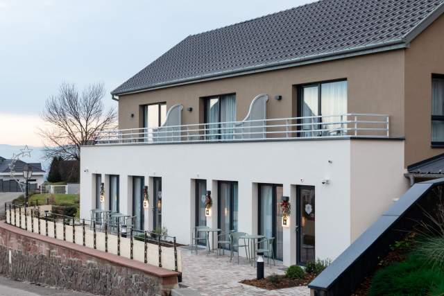 Fassade eines Aparthotels mit Terrassen und separaten Eingängen zu den Unterkünften der Appartements Husseren Collections in der Nähe von Colmar im Elsass