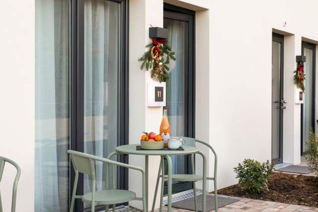 Terrasse eines Aparthotels mit Tisch, Stühlen und Obstkorb vor einem privaten Eingang in der Nähe von Colmar im Elsass