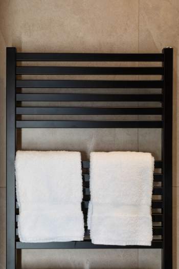 Sèche-serviettes mural avec serviettes blanches dans la salle de bain d’un appart-hôtel près de Colmar, en Alsace