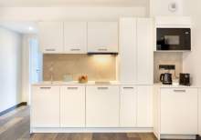 Fully equipped and functional kitchen in a serviced apartment with integrated storage and modern appliances near Colmar, Alsace – Husseren Collections Apartments