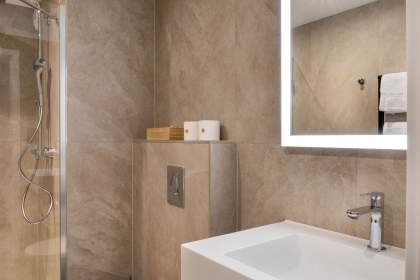 Salle de bain d’un appart-hôtel avec vasque moderne, étagère de rangement et finitions contemporaines près de Colmar, en Alsace