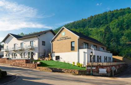 Bâtiment des Appartements Husseren Collections 4 étoiles situé au pied des collines, avec architecture contemporaine et environnement naturel