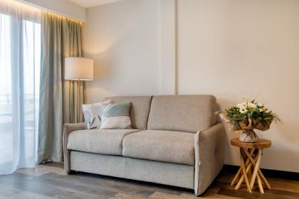 Canapé confortable dans le salon d’un appart-hôtel avec éclairage d’ambiance et décoration soignée près de Colmar, en Alsace